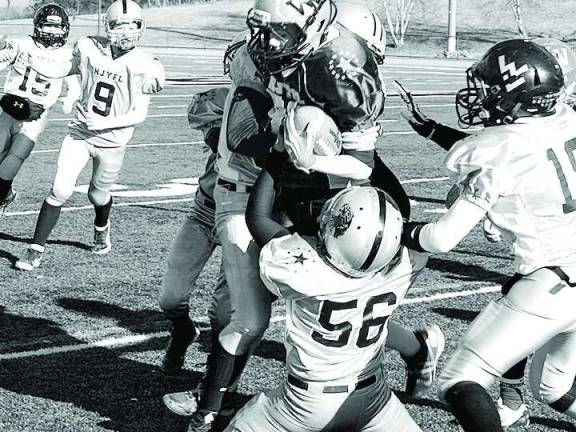 The silver defense converge on purple running back Trevor Fleet in the pee wee game.