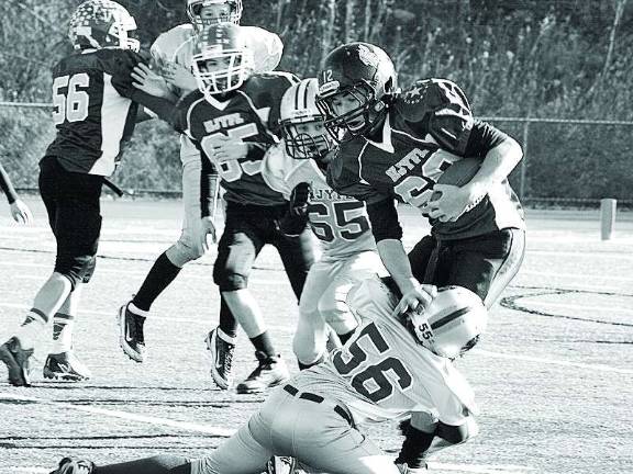 The silvers defensive lineman Rudy Lepara (56) stops purple running back Zack Biango in the back field in the pee wee game.