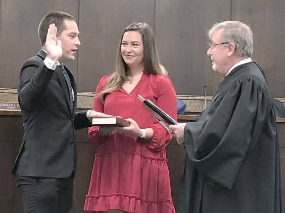 John-Paul Couce is sworn in as deputy mayor. Holding the Bible is Lauren Hennighan.