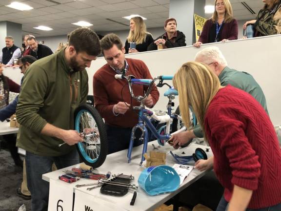 A team works to assemble a child’s bicycle.