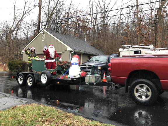 Santa and his assistant are pulled through the Hewitt section of West Milford by members of Fire Company 3 on Sunday, Dec. 17. (Photo by Kathy Shwiff)