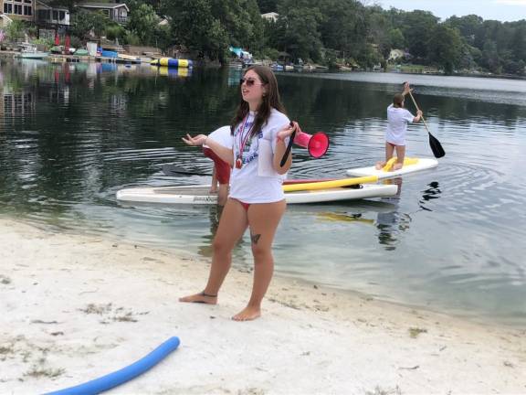 Madi Storch, 19, of West Milford, head lifeguard at Lindy’s Lake, gives instructions before the Distance Swim. She and other lifeguards were on paddle boards in case any of the swimmers needed help or a chance to rest. (Photo by Kathy Shwiff)