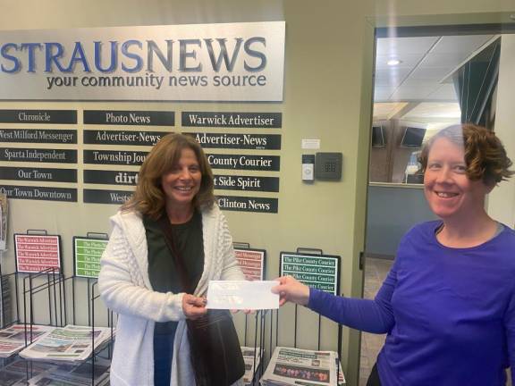 Editor Lisa Reider, right, hands this week’s winner, Cathy Purtell, her $250 prize.