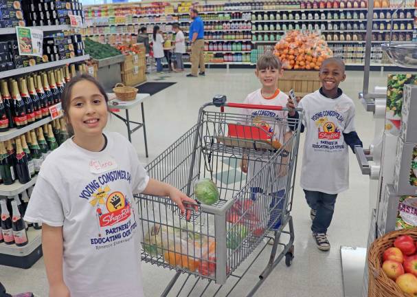 Educated consumerism: Green Hills Elementary school students took part in a youth program to learn about shopping. Elena, Carter, and Aaron fill up their cart with healthy options.