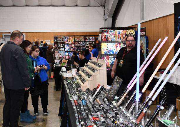 Vendor Michael Enck, right, has light sabers and other items for sale. (Photo by Maria Kovic)