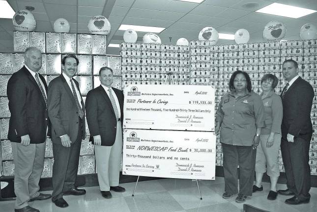 From left: Hank Ramberger, James Scott, David P. Romano, Beverly Ruddock, Patty Lillman, and Byram store manager Mike Boger display the donations made to assist the NORWESCAP Food Bank.