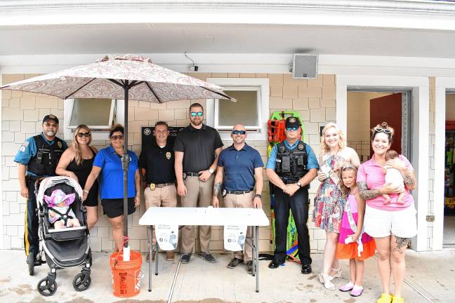 Police officers and other pose at the Ice Cream with a Cop event. Third from right is Miss Newton Danielle Penny and second from right is Little Miss Newton Allena Crowell, 6.
