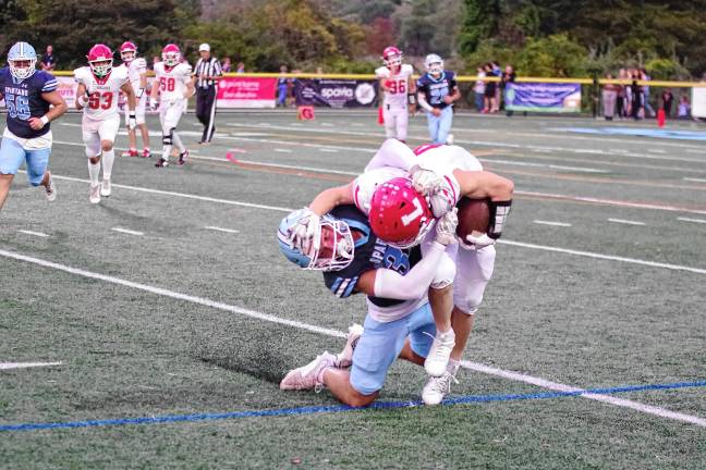 <b>A Lakeland ball carrier is tackled by a Sparta defender.</b>