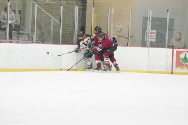 Hockey players battle for control of the puck.