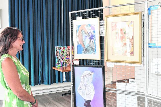 <b>Tina Aue looks at artwork.</b>