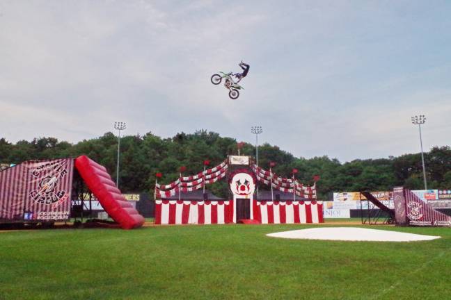 A motorcyclist in the midst of a high flying stunt.