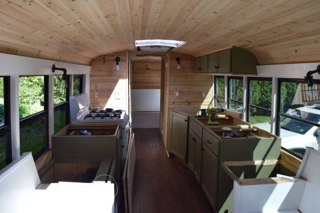 Photo by Erika Norton The inside of the "skoolie" features three couch/beds, a stove, a sink, cabinets, a full shower and a composting toilet.