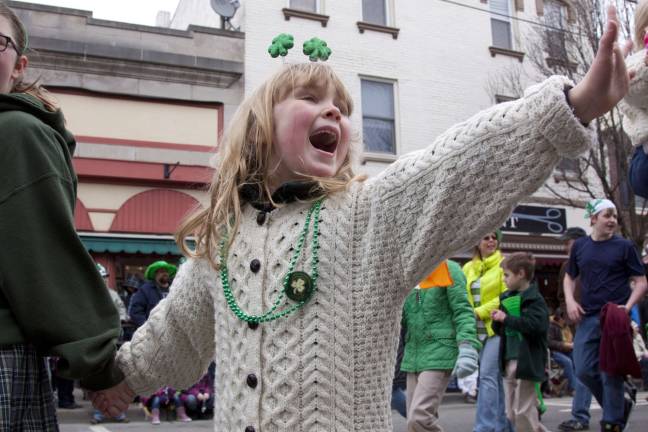An unidentified girl waves to the Grand Marshals and others sitting in the viewing stands.