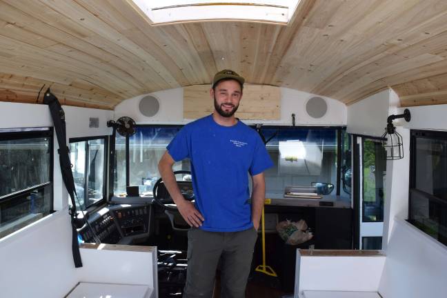 Photo by Erika Norton Michael Fuehrer stands inside his "skoolie," a bus that has been converted into a tiny home.