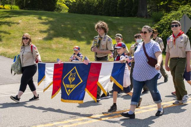Scout leaders, parents, and Cub Scouts and Boy Scouts from Pack/Troop 276 and 151 march in the parade.