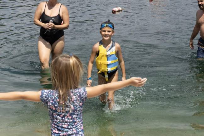 Martina Keeney greets her sister, Isla, 8, as she finishes the distance swim. Isla was the youngest participtant. (Photo by John Caggiano)
