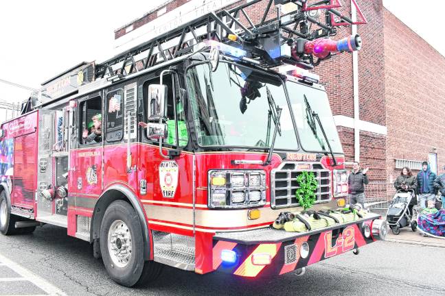 A newton Fire Dept. truck drives through the parade decorated for St. Patrick's Day.