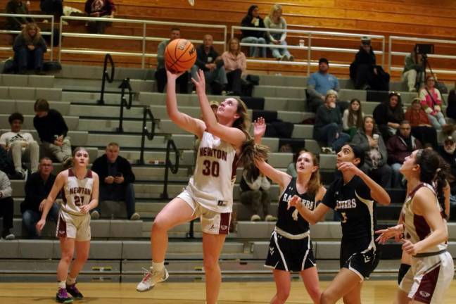 Newton's Caitlyn Pokrywa raises the ball during a shot. She scored 19 points in the game against Wallkill Valley.