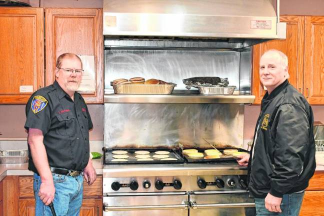 George Hattaway and Bob Wuhrenberg man the stove at Hampton Township Fire &amp; Rescue’s pancake breakfast Sunday, March 10.