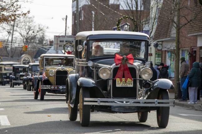 Antique cars make their way down the street during the parade.