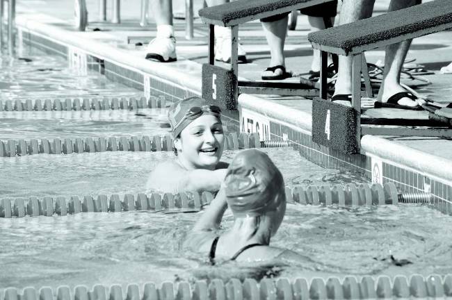 Photos By Robert OsZust From left: Anneliese Rilinger, 16, and Allison VanGlahn, 17, congratulate each other after the first heat in the 100-yard freestyle event.