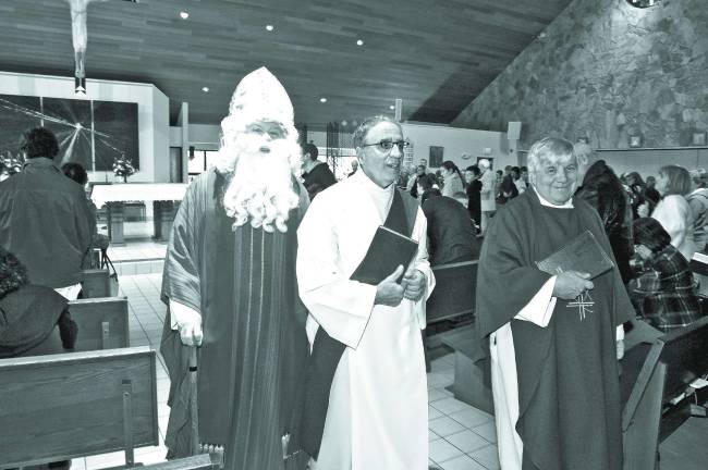 From left, Saint Nicholas, Deacon Tony Chiocco of Sparta and Father Pat leave the mass to go outside and greet the parishoners after the mass.