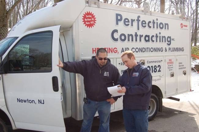 Service Manager Matt Mastrolacasa, left, speaks with owner and CEO Antonio Poccio.