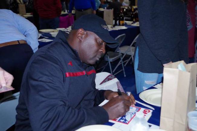 Football legend O.J. Anderson writes his signature on some memorabilia for a fan. Photos by George Leroy Hunter
