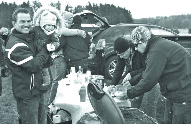 At left John DeGasperis and daughter of Newton, wait to be served at the Tailgate Party.