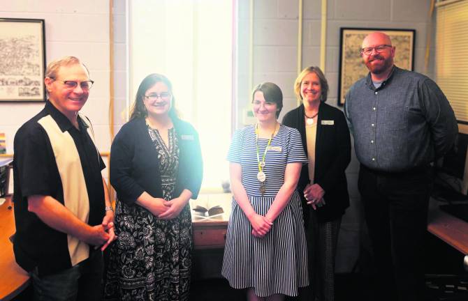 From left, Peter Barrett, Tara Schaberg, Evelynne Albriht, Sara Branagan and Will Porter stand in front of the desk.