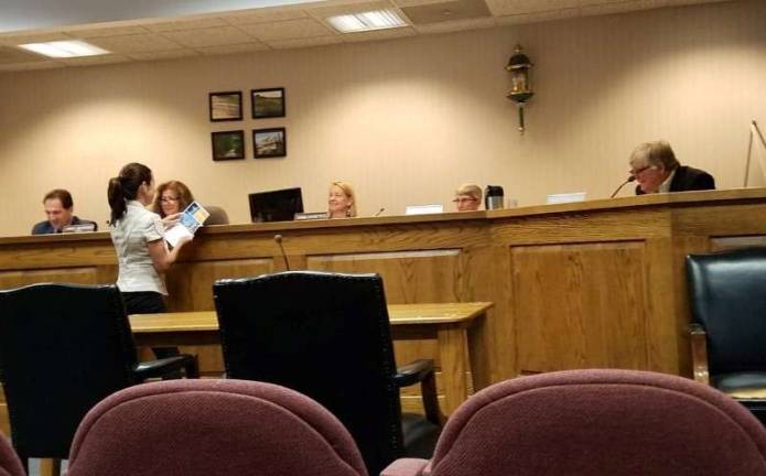 Jackie Espinoza, a representative of JCP&amp;L, stopped by the Andover Township Committee meeting on August 13to deliver information about a new initiative being developed by the utility company to reduce frequency and length of outages. Espinoza is shown here handing materials to (from left) Township Attorney Fred Semrau, Mayor Janis McGovern, Township Administrator Diana Francisco, Deputy Mayor Dolores Blackburn, and Councilman John Carafello. photo by Mandy Coriston