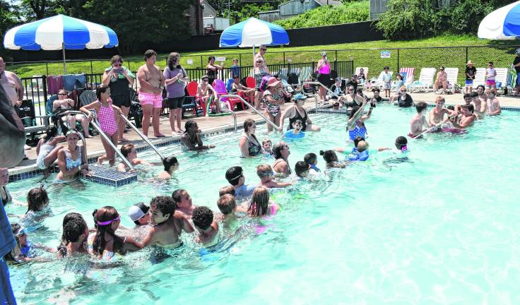 Kids have a tug of war in the pool.