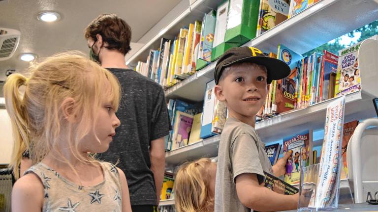 <b>Joni Clawson, 5, of Sandyston</b> with her brother Leo, 8, and sister Mavis, 2, look at books in the new mobile library, Dot, on Wednesday, June 18. (Photos by Theresa Esposito)