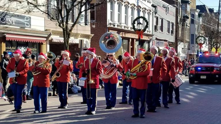 The Franklin Community Band pauses between Christmas carols during the Annual Holiday Parade in Newton on Saturday, Nov 30, 2019.