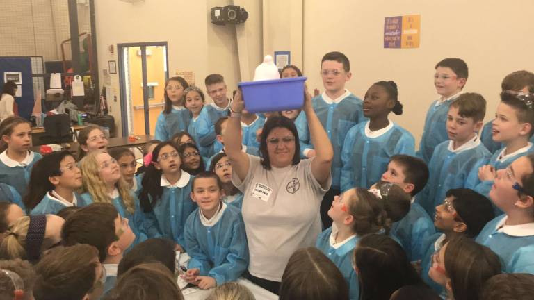 Shannon Gunter, an employee of Bayer standing in center, shows Reverend Brown fourth-grade students &quot;Elephant Toothpaste,&quot; an experiment mixing yeast and hydrogen peroxide, during STEM Day on Friday at Reverend George A. Brown Memorial School in Sparta. Photos by Anthony Spaulding, director of Communications, POpe John XXIII HS