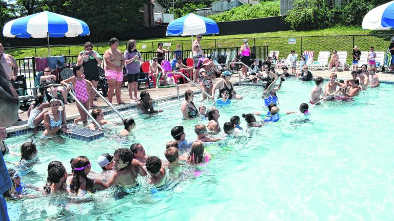 Kids have a tug of war in the pool.