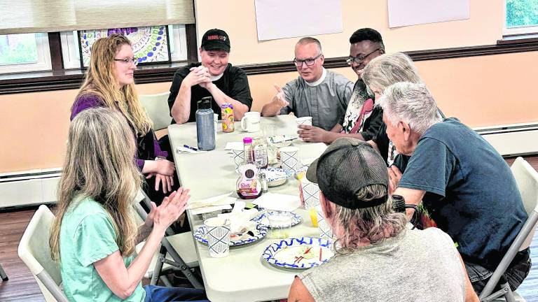 The Reverend Chris Streeter and the Reverend Patricia Lyons converse with Emily Jerger, Project Self-Sufficiency, and attendees at the New Beginnings Community Breakfast at Christ Church Newton.