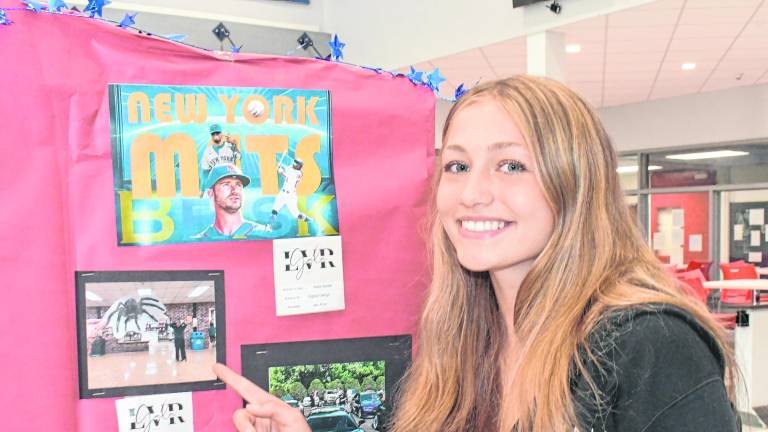 Mariana Akerman points at her artwork.