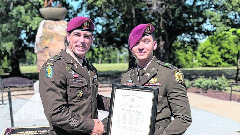 Stephen Rozek of Andover, right, poses with another officer and a certificate signifying his promotion to captain in the U.S. Army.