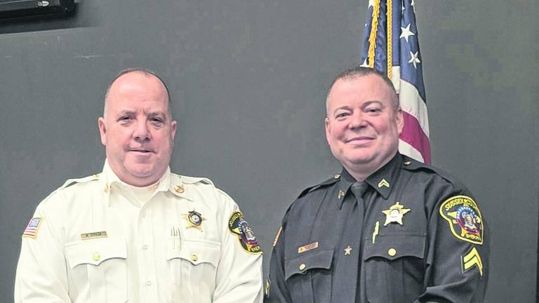 Sussex County Sheriff Michael Strada stands retiring Corporal Brian Snyder.