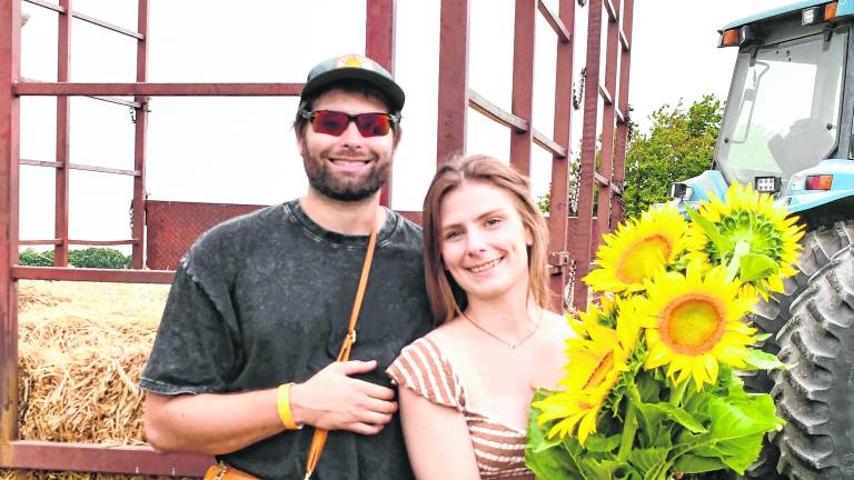 Francis Drake and Kimberly Osolin of Flanders pose with sunflowers.